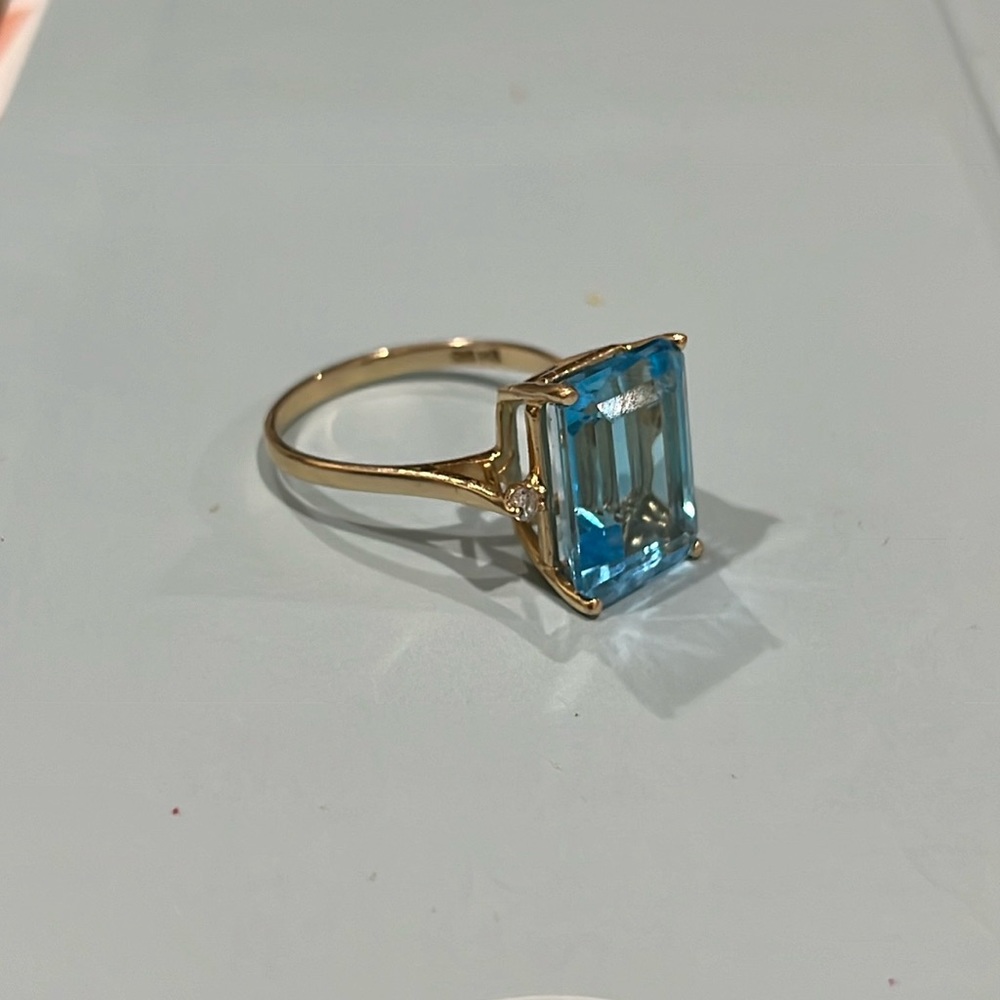 Gold and blue stone ring with tiny diamonds on the left and the right